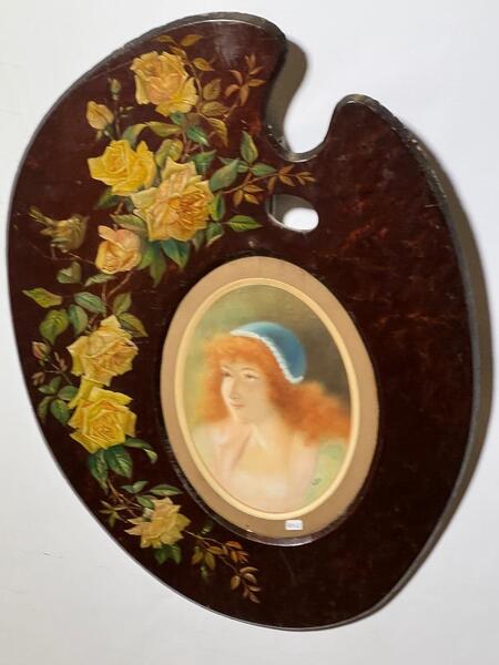 A painted painter’s palette with a drawing of a girl